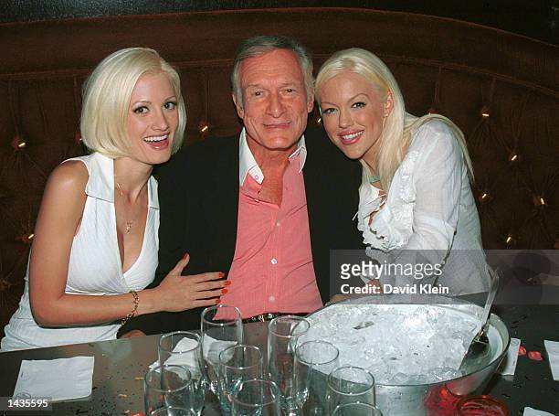 Playboy models Holly Madison and Tiffany Holiday hug their boyfriend Hugh Hefner during a birthday dinner party for Hef's two other girlfriends...