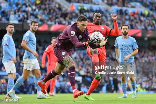Ederson of Manchester City is challenged by Danny Welbeck of Brighton & Hove Albion during the Premier League match between Manchester City and...
