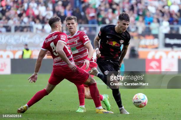Dominik Szoboszlai of RB Leipzig runs with the ball from Ermedin Demirovic of Augsburg during the Bundesliga match between FC Augsburg and RB Leipzig...