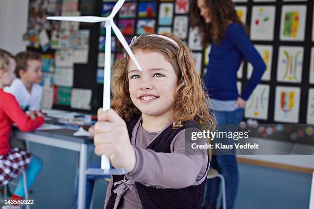 girl smiling, holding miniature wind mill - windmill denmark stock pictures, royalty-free photos & images
