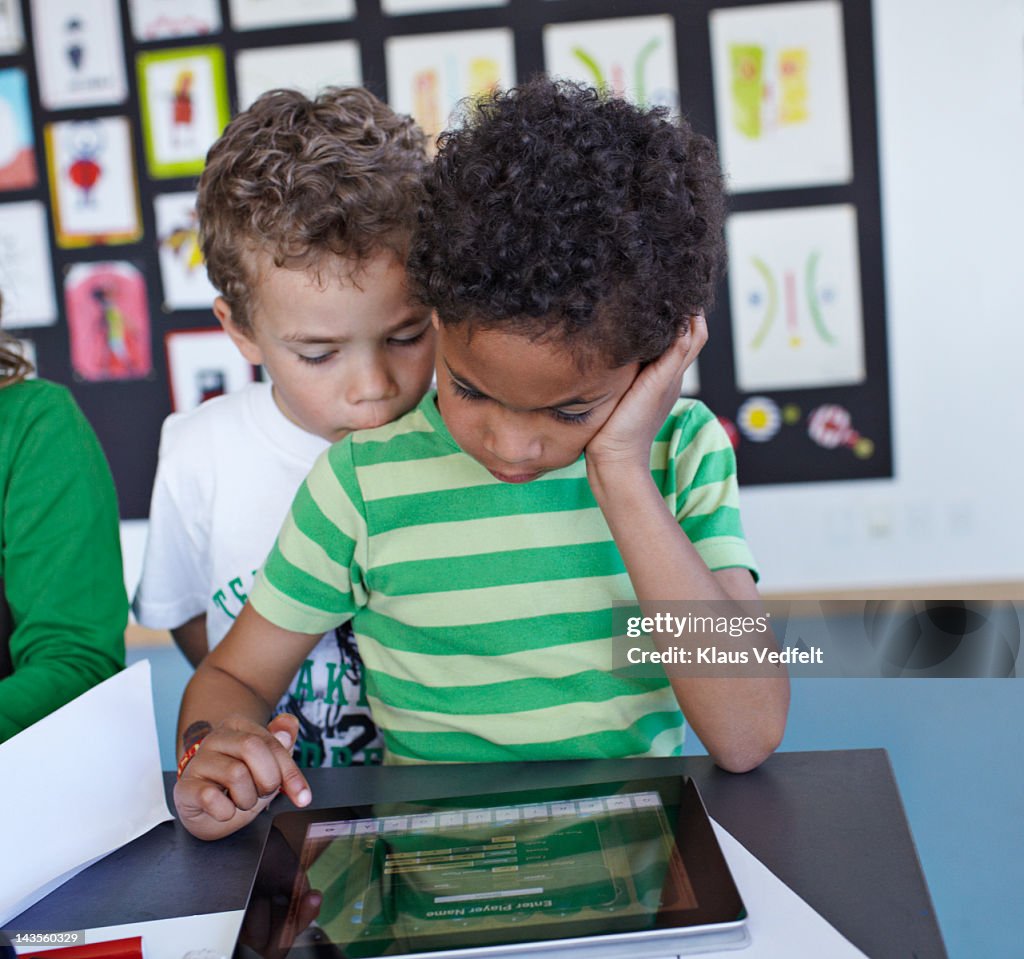 2 boys looking at tablet