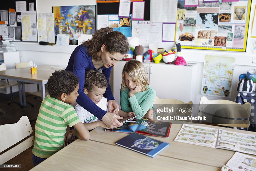 Teacher with children using tablet