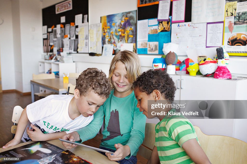Kids looking at tablet in classroom
