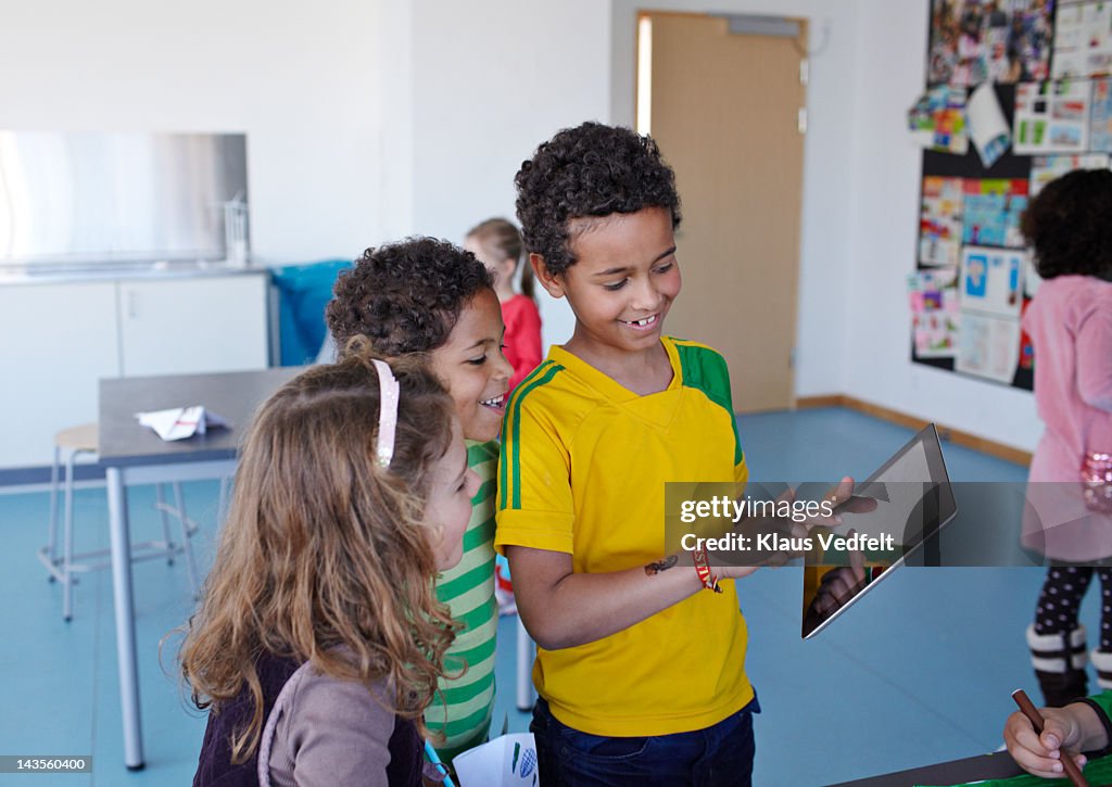 Children looking at tablet in school class