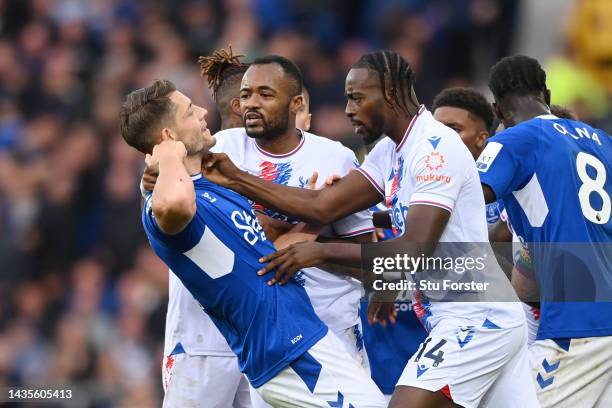 Jean-Philippe Mateta and Jordan Ayew of Crystal Palace clash with James Tarkowski of Everton during the Premier League match between Everton FC and...