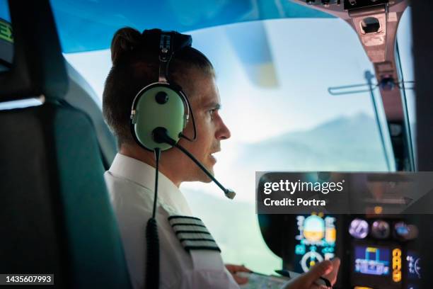 rear view of a male pilot flying helicopter - pilot bildbanksfoton och bilder