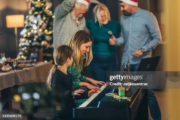 multigeneration family singing christmas song at house party - family singing stock pictures, royalty-free photos & images