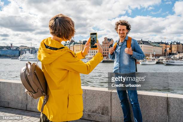 ガールフレンドはストックホルムのキーサイドで彼女のボーイフレンドの写真を撮る - stockholm ストックフォトと画像