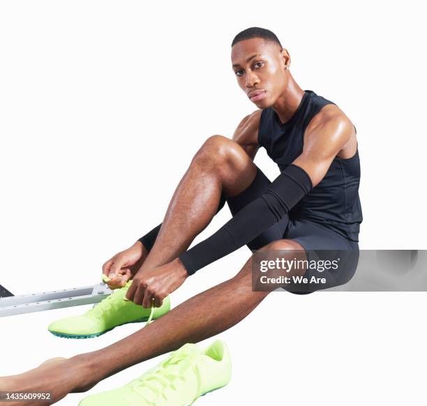 sportsperson putting on shoes against white background - black men feet stock-fotos und bilder