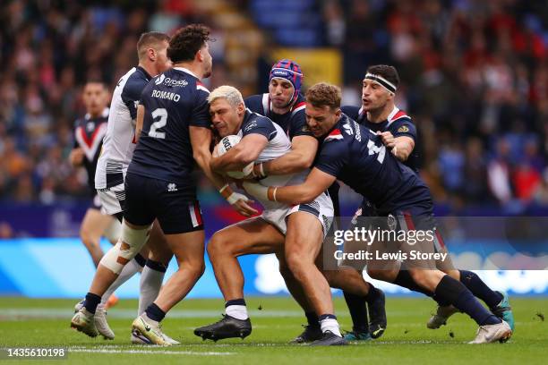 Ryan Hall of England is tackled by Arthur Romano, Benjamin Jullien and Paul Seguier of France during the Rugby League World Cup 2021 Pool A match...