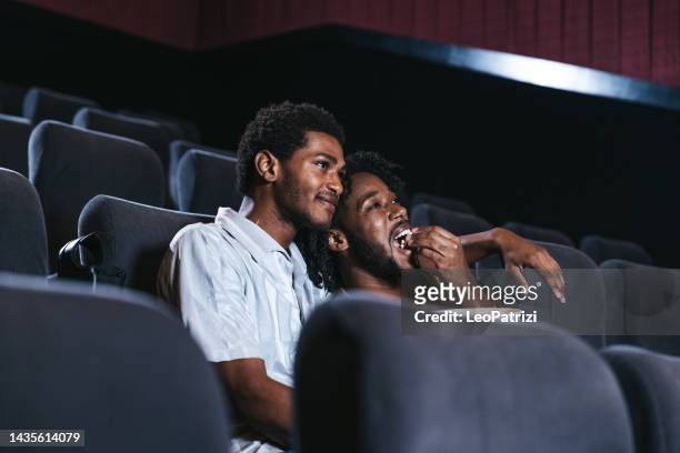 couple enjoying a movie at the cinema - film premiere stock pictures, royalty-free photos & images