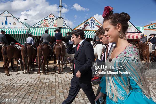 Young woman wearing traditional 'Sevillana' dress walks through the Seville April Fair on April 28, 2012 in Seville, Spain. Dating back to 1847, the...