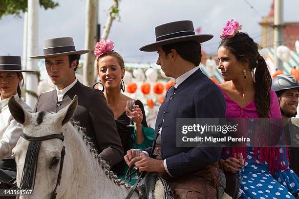 Young couples wear the traditional 'Sevillana' dress sitting on horseback at the Seville April Fair on April 28, 2012 in Seville, Spain. Dating back...