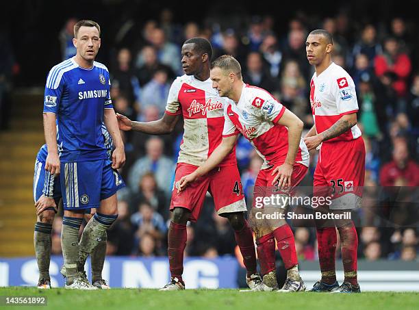 John Terry of Chelsea is watched by Anton Ferdinand , Clint Hill and Nedum Onuoha of Queens Park Rangers during the Barclays Premier League match...