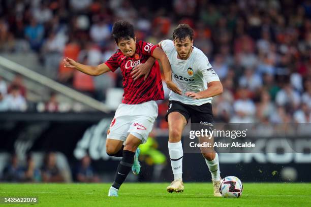 Nico Gonzalez of Valencia battles for possession with Lee Kang-In of RCD Mallorca during the LaLiga Santander match between Valencia CF and RCD...