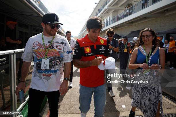 Carlos Sainz of Spain and Ferrari walks in the Paddock with Conor Daly prior to final practice ahead of the F1 Grand Prix of USA at Circuit of The...