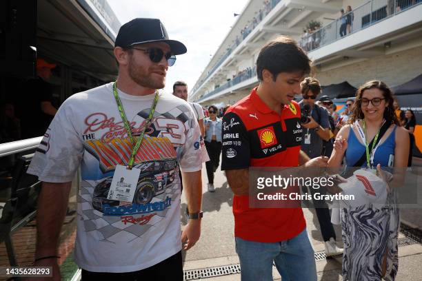 Carlos Sainz of Spain and Ferrari walks in the Paddock with Conor Daly prior to final practice ahead of the F1 Grand Prix of USA at Circuit of The...
