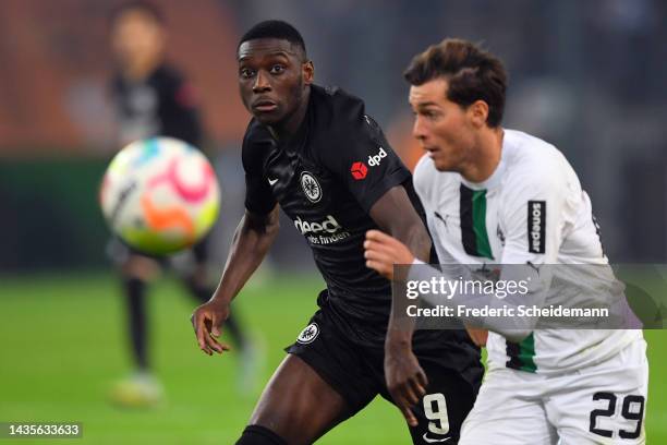 Randal Kolo Muani of Eintracht Frankfurt is challenged by Joe Scally of Borussia Monchengladbach during the Bundesliga match between Borussia...