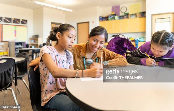 indigenous navajo teacher helping students with their work - north american tribal culture 個照片及圖片檔