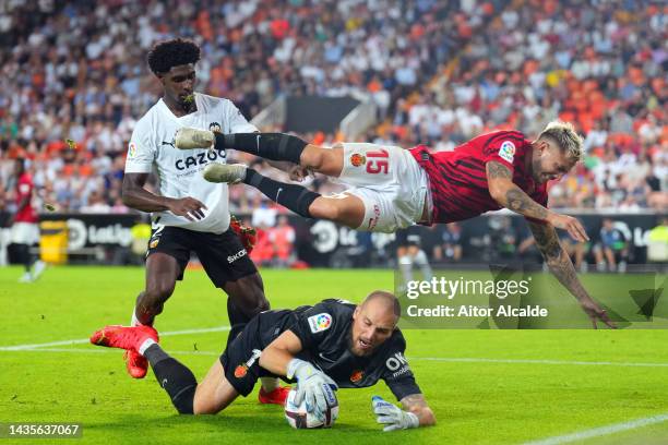 Pablo Maffeo and Predrag Rajkovic of RCD Mallorca battle for possession with Thierry Correia of Valencia during the LaLiga Santander match between...