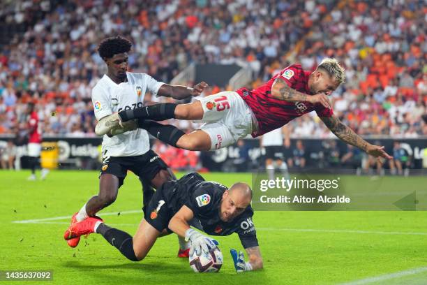 Pablo Maffeo and Predrag Rajkovic of RCD Mallorca battle for possession with Thierry Correia of Valencia during the LaLiga Santander match between...