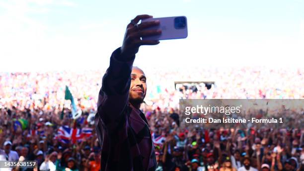 Lewis Hamilton of Great Britain and Mercedes takes a photo on the fan stage prior to final practice ahead of the F1 Grand Prix of USA at Circuit of...
