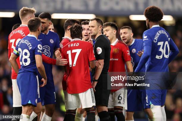 Match referee Stuart Attwell is confronted after awarding a penalty to Chelsea during the Premier League match between Chelsea FC and Manchester...