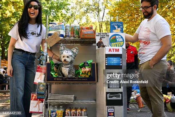 Cat Liu and Kevin Condardo wheel Mimi, a bichon dog, dressed as the bodega cat during the Annual Tompkins Square Halloween Dog Parade on October 22,...