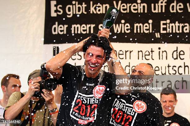 Sporting manager Bruno Huebner of Frankfurt gets a champaign shower of kit manager Franco Lionti and celebrates the ascent to the 1. Bundesliga after...