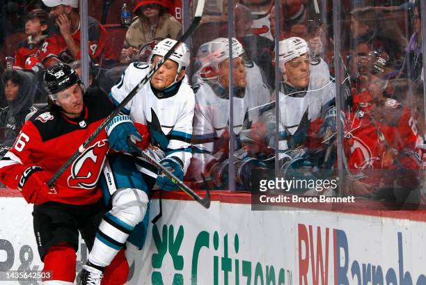 Radim Simek of the San Jose Sharks is hit into the boards by Erik Haula of the New Jersey Devils during the second period at the Prudential Center on...