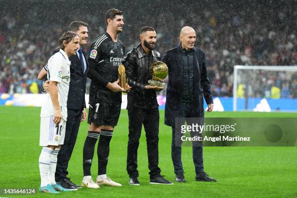 Thibaut Courtois is presented with the Yashin Trophy with Karim Benzema of Real Madrid as they are presented with the Ballon d'Or trophy prior to the...