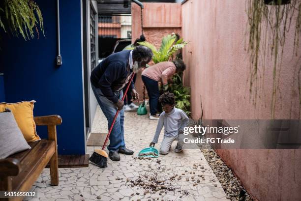 großvater und enkel fegen zu hause den boden des hofes - sweeping stock-fotos und bilder