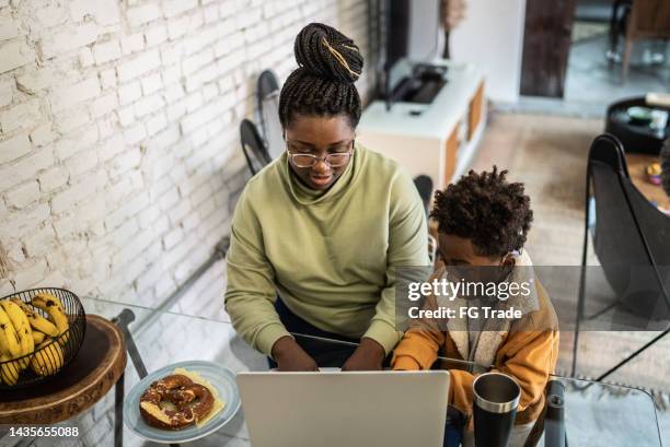 mother and son using the laptop in the living room at home - hearing loss at work stock pictures, royalty-free photos & images