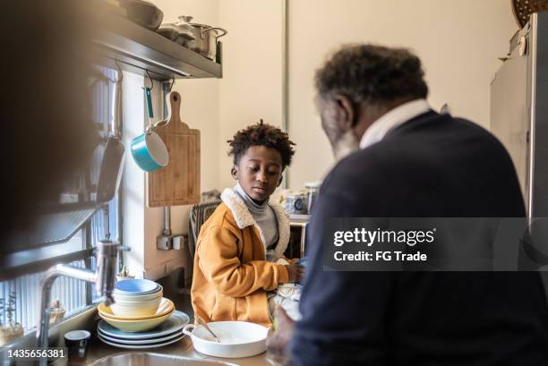 grandson helping grandfather cooking at home - grandfather and grandson stock pictures, royalty-free photos & images