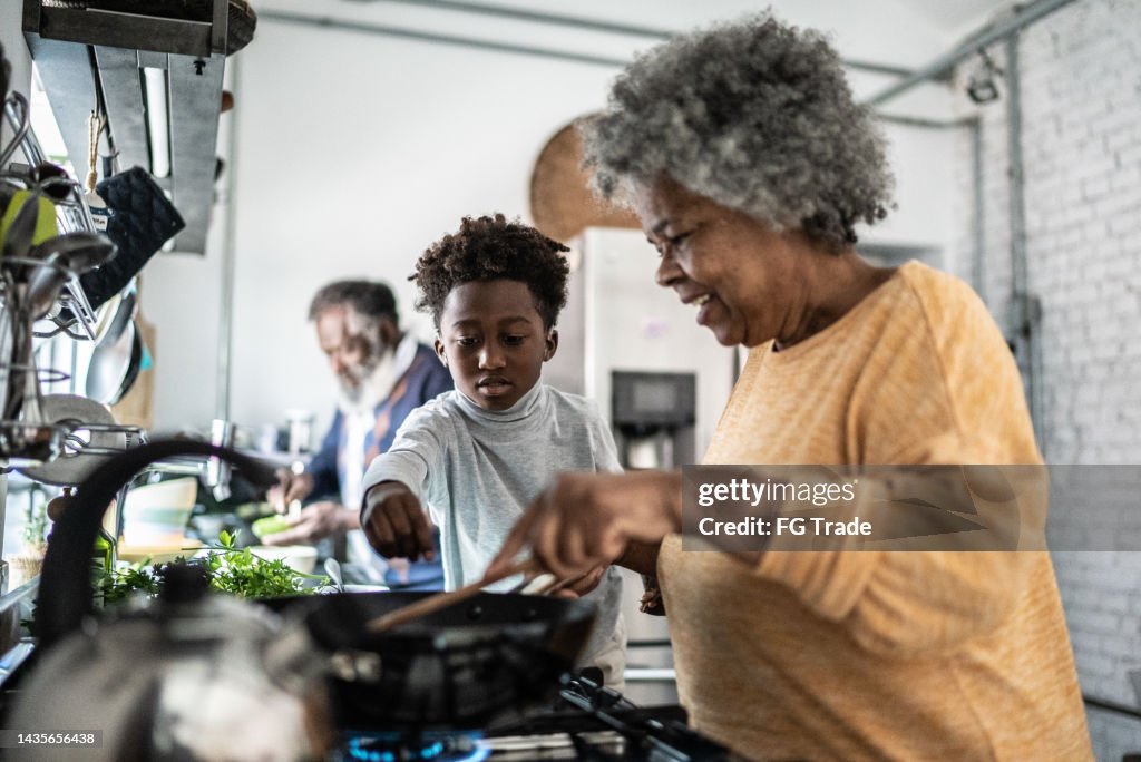 Grandson helping his grandmother cooking at home