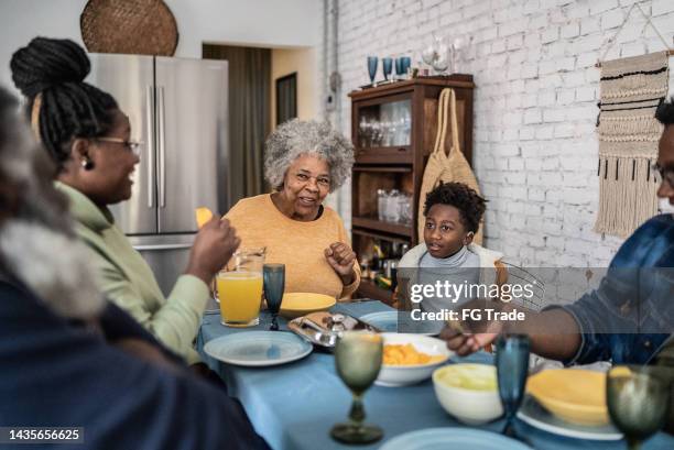 family talking and eating during the lunch at home - woman normal old diverse stock pictures, royalty-free photos & images