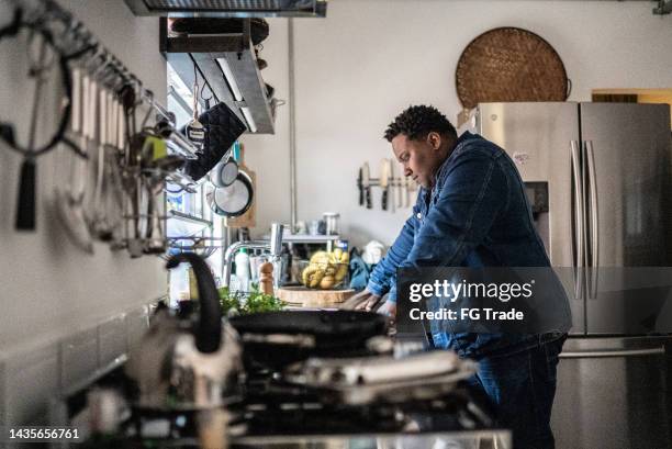 sad mid adult man in the kitchen at home - dyspnea stock pictures, royalty-free photos & images