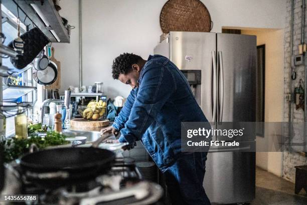 sad mid adult man in the kitchen at home - smart homes stockfoto's en -beelden