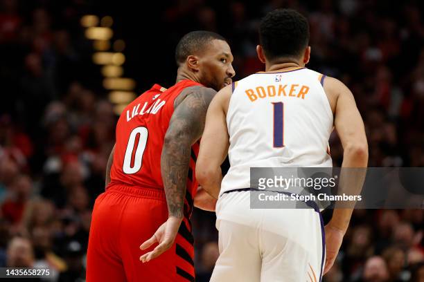 Damian Lillard of the Portland Trail Blazers and Devin Booker of the Phoenix Suns react during the fourth quarter at Moda Center on October 21, 2022...