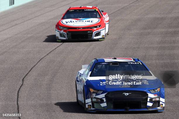 Yeley, driver of the Jacob Companies Ford, and Kyle Larson, driver of the Valvoline Chevrolet, drive during qualifying for the NASCAR Cup Series...