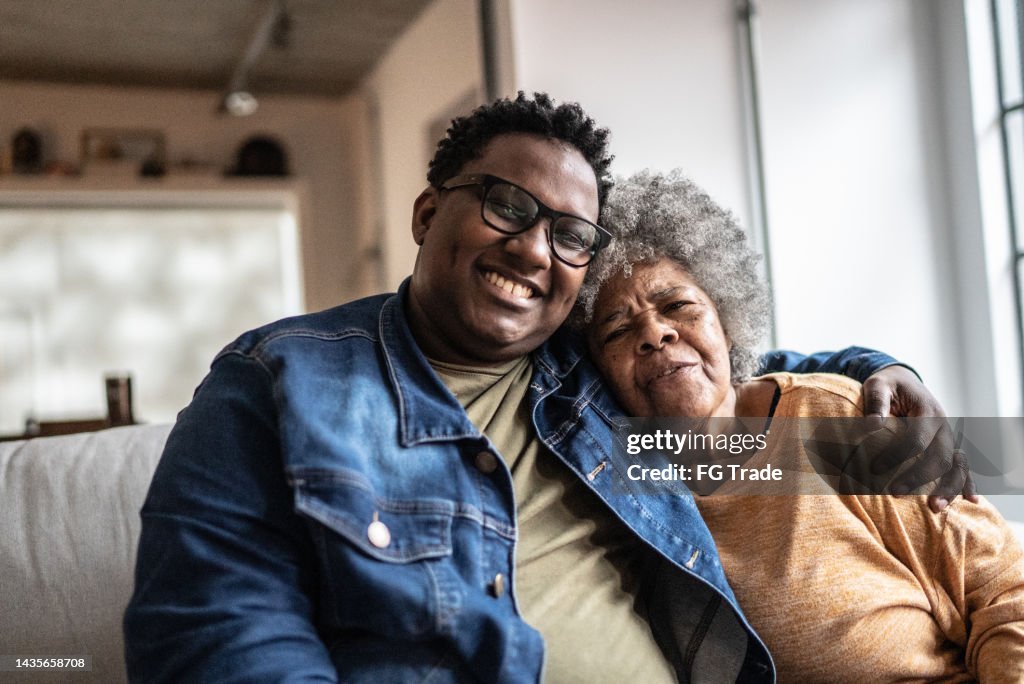 Portrait of mother and son emnbracing in the living room at home