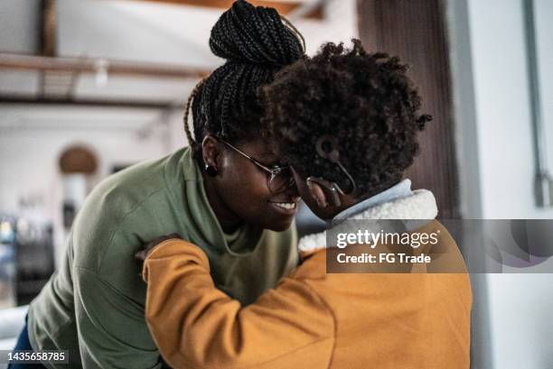 mother and son touching their heads at home - hearing aids stock pictures, royalty-free photos & images