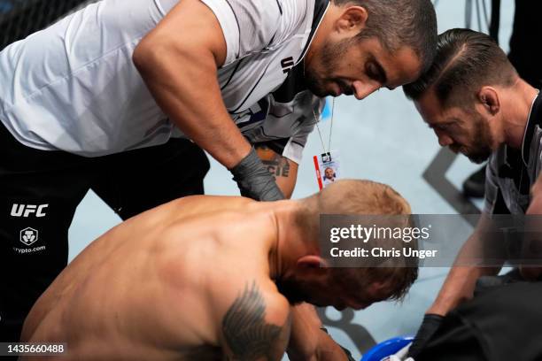 The coaches of TJ Dillashaw attempt to reset his shoulder between rounds of his UFC bantamweight championship fight against Aljamain Sterling during...