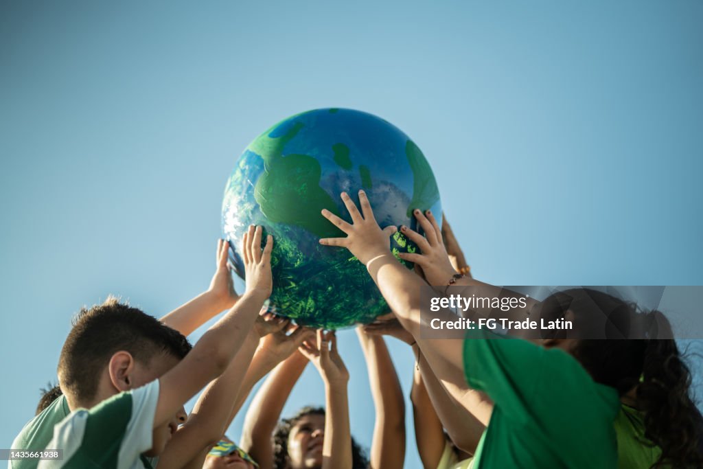 Children holding a planet outdoors