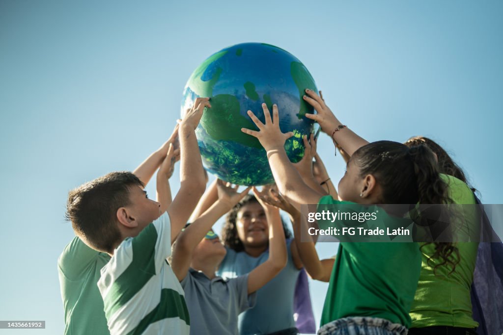Bambini che tengono un pianeta all'aperto
