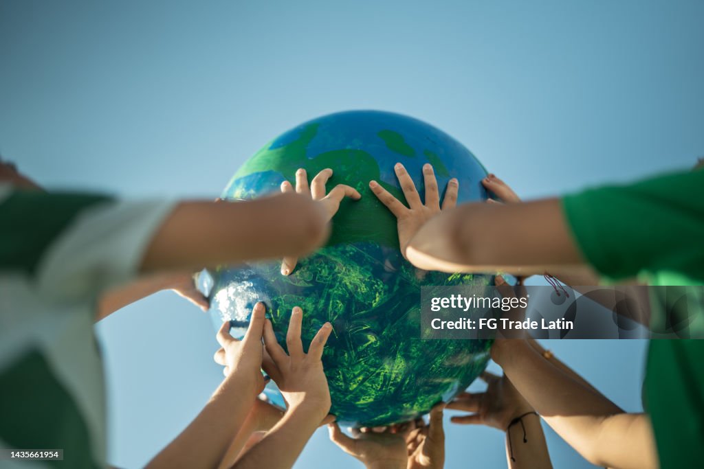Children holding a planet outdoors