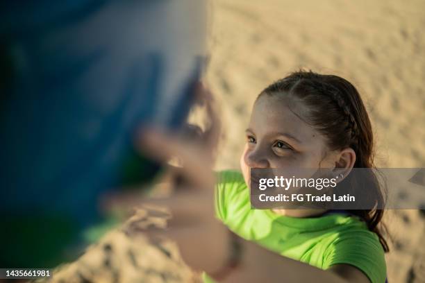 girl holding a planet sphere at the beach - world children day stock pictures, royalty-free photos & images