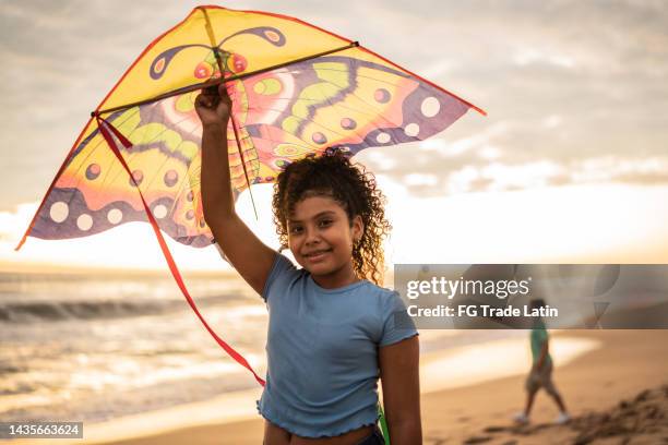 portrait of girl holding a kite at the beach - kite toy stock pictures, royalty-free photos & images