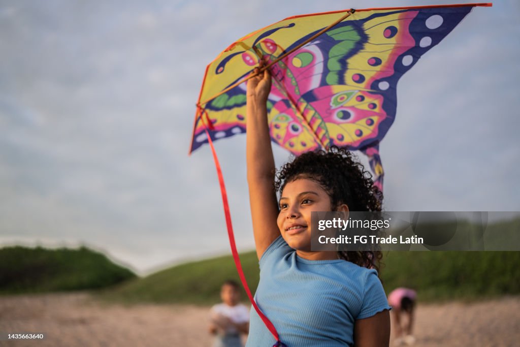 Girl holding a kite while contemplating at the beach