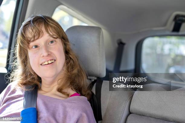 happy nonverbal young woman takes ride in the car - verstandelijk gehandicapt stockfoto's en -beelden